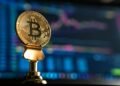 selective focus photo of Bitcoin near monitor